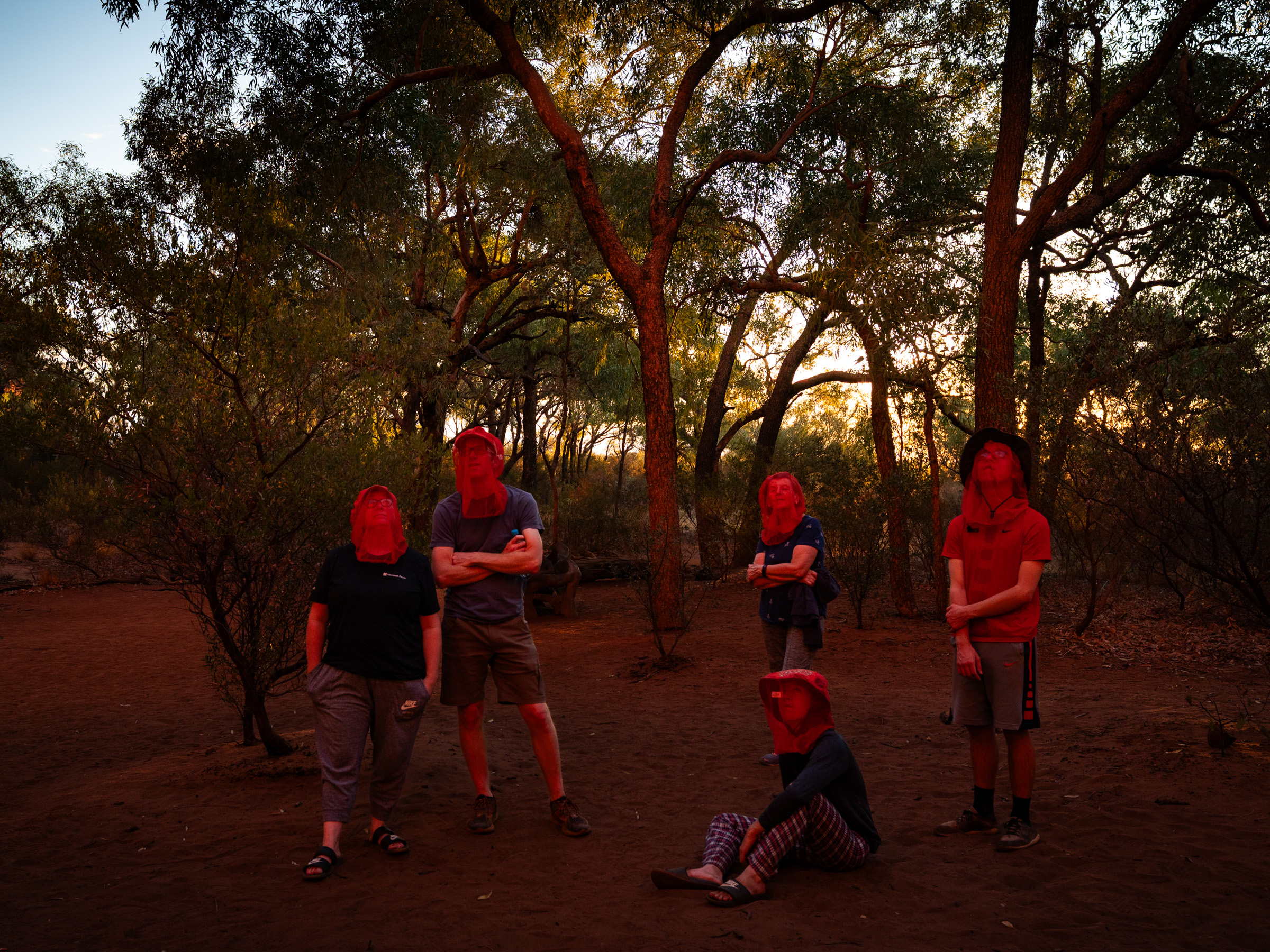 Visitors under red light at Uluru at dusk, Northern Territory, 2019 — documentary photography by Matthew Abbott