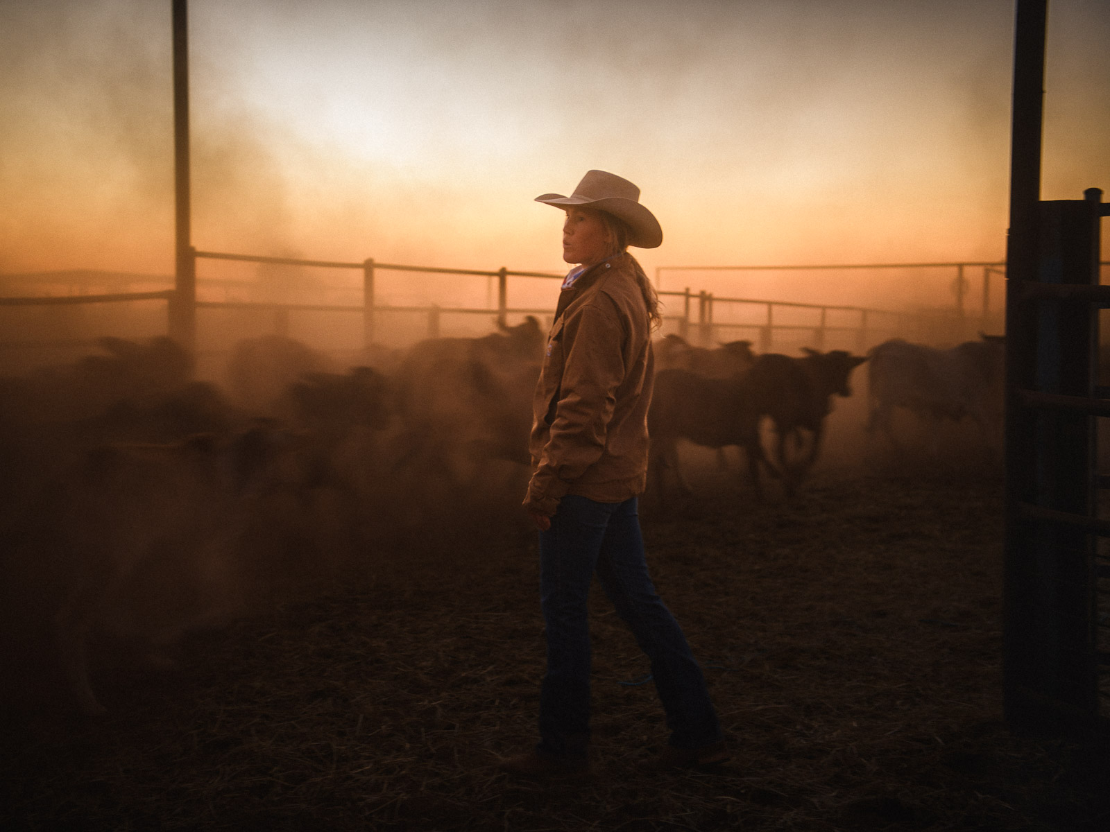 Cowgirl in the yards at dusk, outback cattle station, Australia — documentary photography by Matthew Abbott